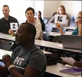 Students holding up cards with images on them that can be scanned as voting devices.