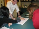 Photo of three students studying a lab notebook.