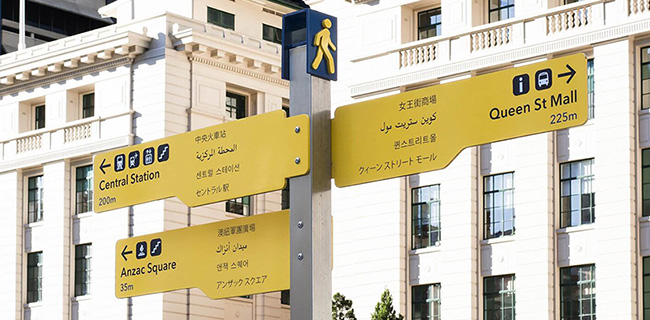 Brightly colored signs have 5 different languages written on them. 