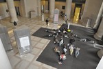 Photo of about 15 students lying on the floor of MIT’s Lobby 7, just inside a heavily-used doorway.