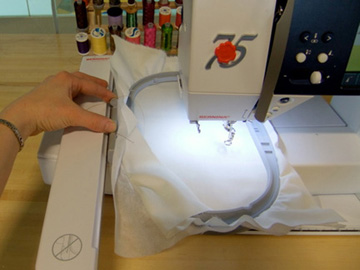 Photo showing hand attaching a presser foot on a sewing machine.