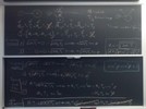 Nuclear reaction related equations on two blackboards.