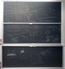 Photon interaction related equations, tables, and graphs on two blackboards.