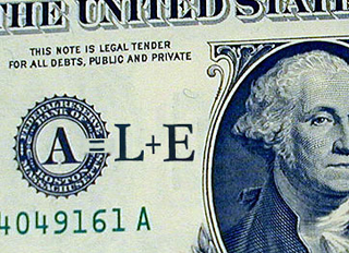 Close up of dollar bill with A equals L plus E written on it.