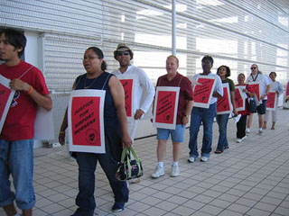 A line of picketers wearing sandwich boards.