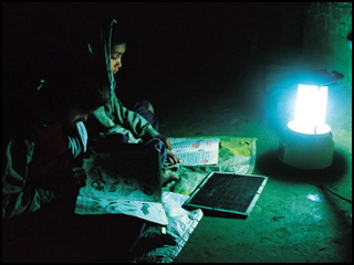 A girl reading in the dark with a lantern.
