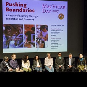 8 panelists sit on stage in front of a the title 'Pushing Boundaries' at MacVicar Day 2017.