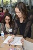 A woman is teaching a girl about electronic components.