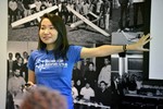 A photo of a woman speaking at the front of a room.