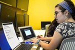 A photo of a girl sitting at a laptop.