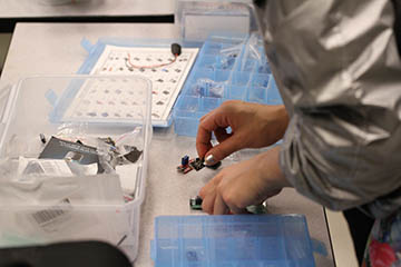 A pair of hands working on circuits and wires during an electronic prototyping project.